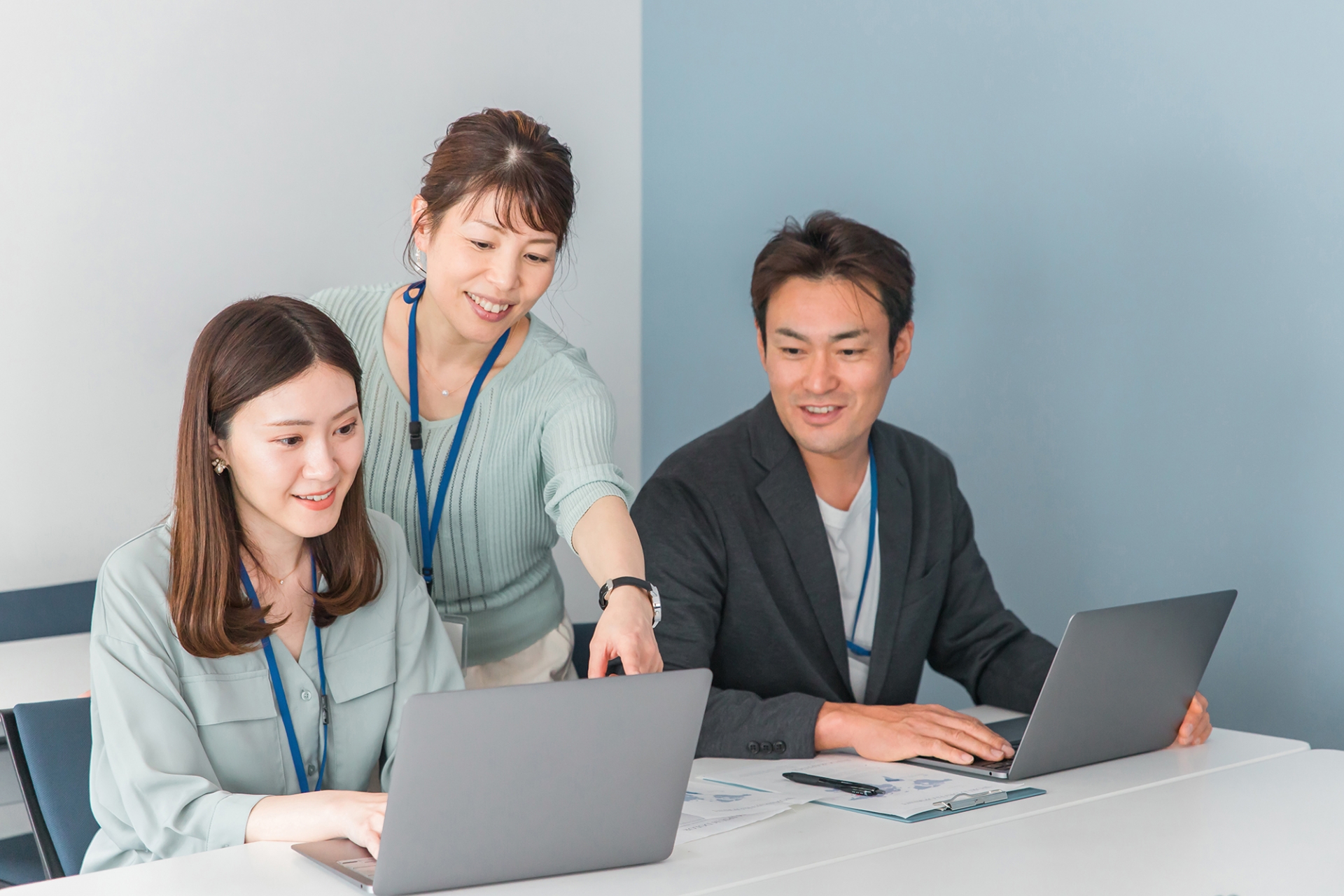 男女3人が2つのPCを目の前に置き穏やかに談笑している