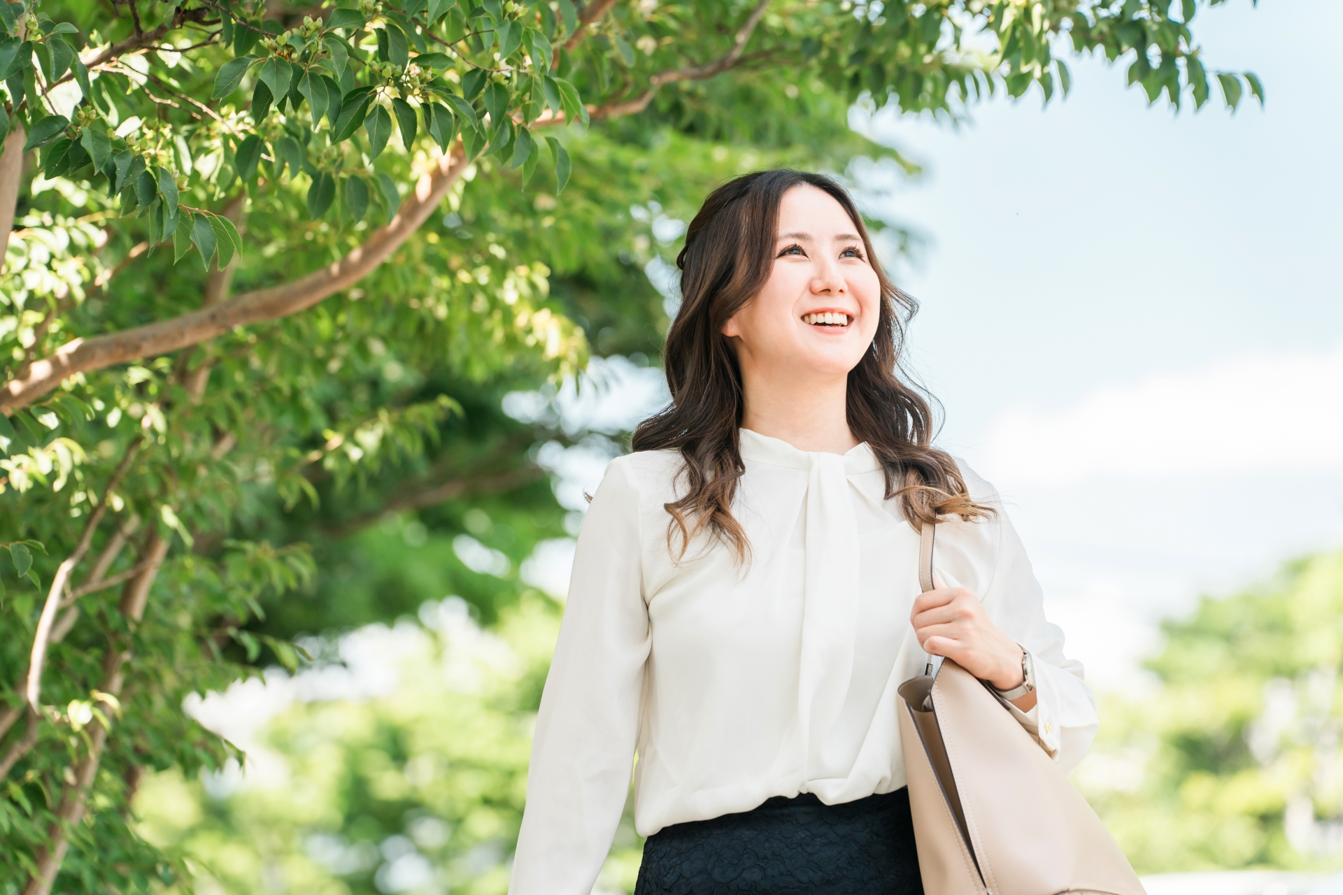 晴れた日に木の下で散歩する女性