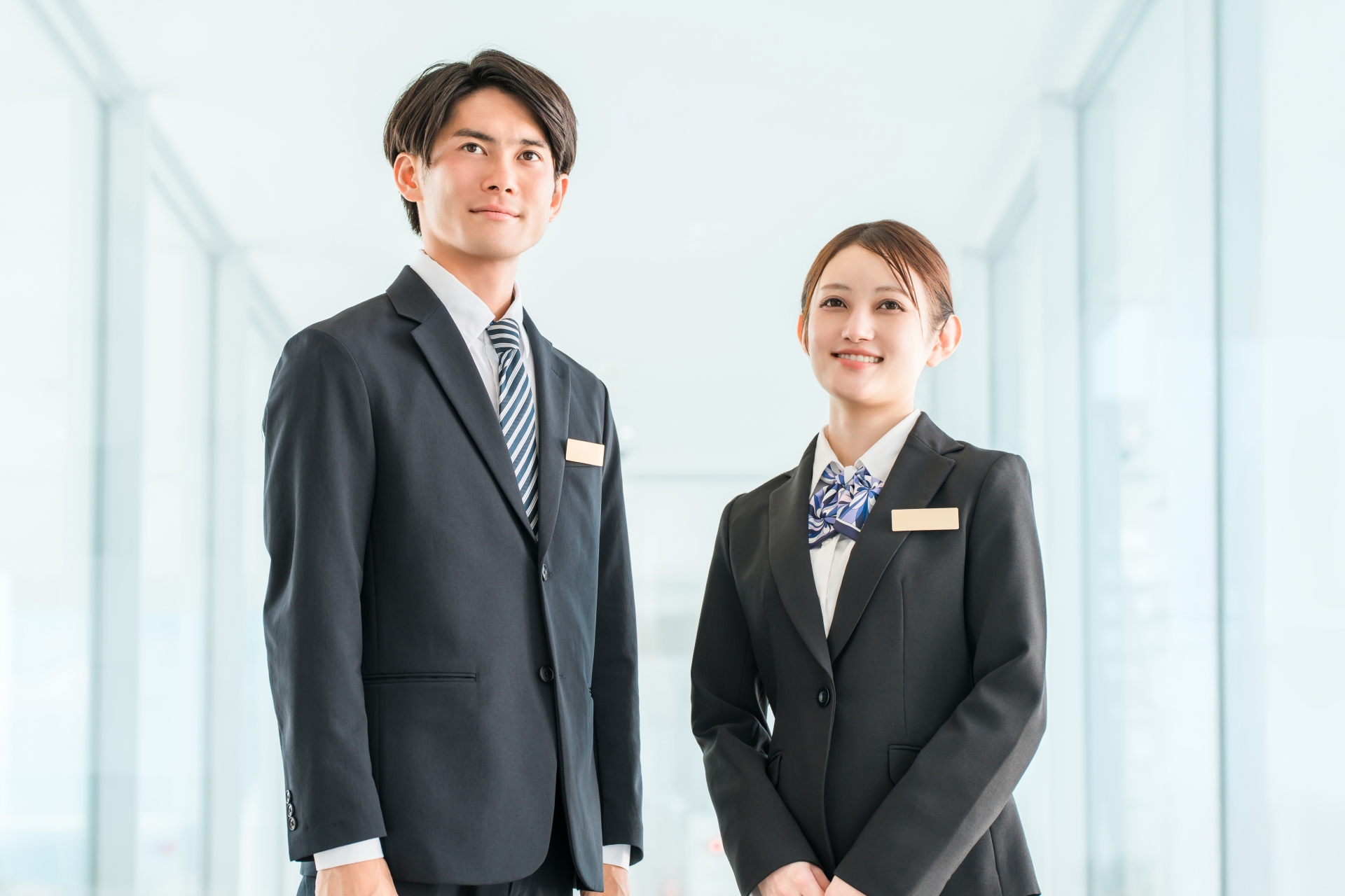 スーツを着てこちらを見ている若い男女のビジネスパーソン