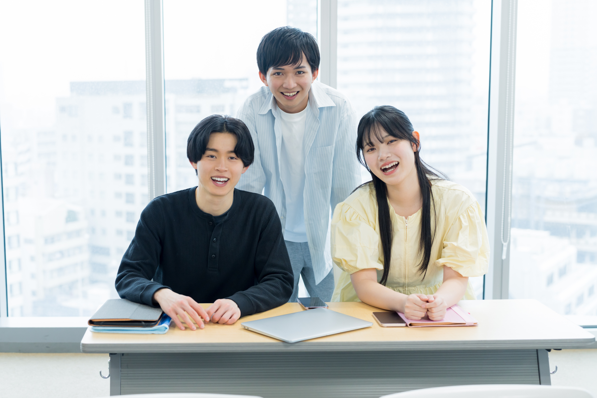 カジュアルな服装の男女がこちらを見て微笑んでいる。