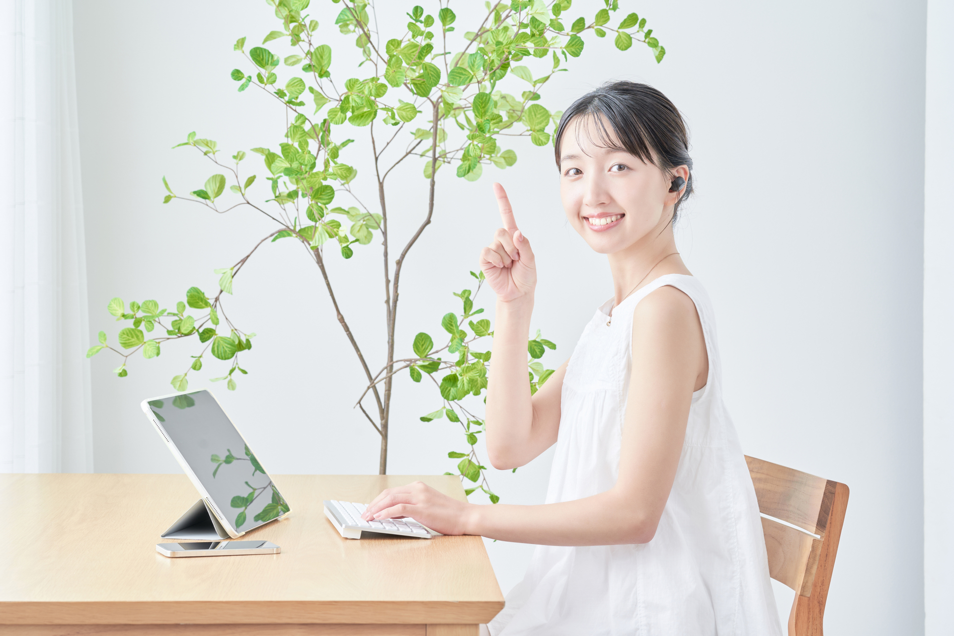 こちらを見て人差し指を立ててポイントを示すようにしている女性
