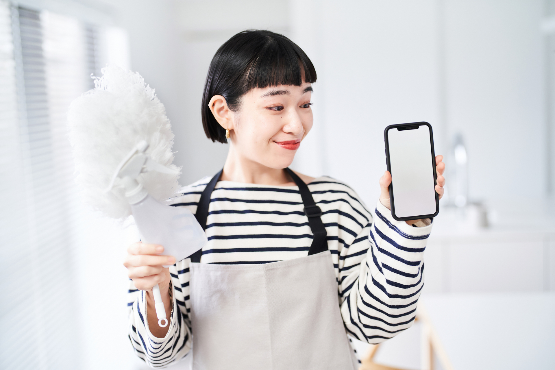 スマホをもってこちらを見ている女性